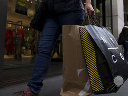 FILE - A shopper carries bags down Fifth Avenue on Black Friday, Nov. 25, 2022, in New York. Holiday sales rose as shoppers showed some resilience during the most important shopping season despite surging prices on everything from food to rent. (AP Photo/Julia Nikhinson, File )