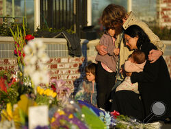 FILE - A family gathers at a memorial outside the Star Ballroom Dance Studio, the site of a mass shooting, on Tuesday, Jan. 24, 2023, in Monterey Park, Calif. In the course of 48 hours, two gunmen went on shooting rampages at both ends of California that left 18 dead and 10 wounded. (AP Photo/Ashley Landis, File)