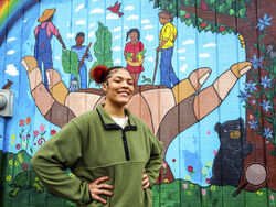 Kailani Taylor-Cribb stands in front of mural at a neighborhood community garden in Asheville, N.C., on Tuesday, Jan. 31, 2023. She knows, looking back, that things could have been different. While she has no regrets about leaving high school, she says she might have changed her mind if someone at school had shown more interest and personal attention to her needs. “All they had to do was take action,” she said. “There were so many times they could have done something. And they did nothing.” (AP Photo/Kathy 