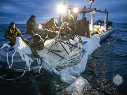 This image provided by the U.S. Navy shows sailors assigned to Explosive Ordnance Disposal Group 2 recovering a high-altitude surveillance balloon off the coast of Myrtle Beach, S.C., Feb. 5, 2023. (U.S. Navy via AP)