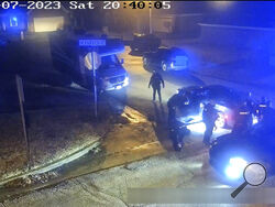 In this image from video released and partially redacted by the city of Memphis, Tenn., on Jan. 27, 2023, Tyre Nichols leans against a car after a brutal attack by five Memphis Police officers on Jan. 7, in Memphis. Officer Demetrius Haley, who is standing bent over in front of Nichols, is seen taking photographs of Nichols, which he sent to other officers and a female acquaintance. The new revelation about Haley's actions were released Tuesday, Feb. 7, in documents that provide a scathing account of what a