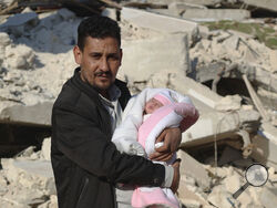 Khalil al-Sawadi holds Afraa, a baby girl who was born under the rubble caused by an earthquake that hit Syria and Turkey, in the town of Jinderis, Aleppo province, Syria, Monday, Feb. 20, 2023. Afraa left the hospital and has gone to her new home with her paternal aunt's family Monday, Feb. 20. (AP Photo/Ghaith Alsayed)