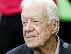 FILE - Former President Jimmy Carter sits on the Atlanta Falcons bench before the first half of an NFL football game between the Atlanta Falcons and the San Diego Chargers, Oct. 23, 2016, in Atlanta. Carter has entered home hospice care after a series of short hospital stays. The Carter Center said in a statement Saturday, Feb. 18, 2023, that Carter, 98, “decided to spend his remaining time at home with his family and receive hospice care instead of additional medical intervention.” (AP Photo/John Bazemore,