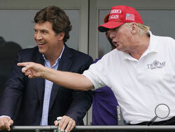Tucker Carlson, left, and former President Donald Trump, talk while watching golfers on the 16th tee during the final round of the LIV Golf Invitational at Trump National in Bedminster, N.J., July 31, 2022. A defamation lawsuit against Fox News is revealing blunt behind-the-scenes opinions by its top figures about Donald Trump, including a Tucker Carlson text message where he said “I hate him passionately.” Carlson's private conversation was revealed in court papers at virtually the same time as the former 