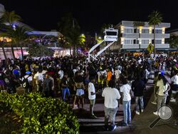 Crowds gather at Ocean Drive and 8th during spring break on Saturday, March 18, 2023, in Miami Beach, Fla. Miami Beach officials imposed a curfew beginning Sunday night, March 19, after two fatal shootings and rowdy, chaotic crowds that police have had difficulty controlling. (D.A. Varela/Miami Herald via AP)