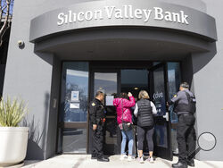 FILE - Security guards let individuals enter the Silicon Valley Bank's headquarters in Santa Clara, Calif., March 13, 2023. When two tech-linked U.S. banks failed this month, the investors who lost millions included public-sector pension funds responsible for ensuring the retirements of teachers, firefighters and other government workers. (AP Photo/ Benjamin Fanjoy, File)