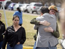 A student, right, hugs a parent as they are reunited following a shooting at East High School, Wednesday, March 22, 2023, in Denver. (AP Photo/David Zalubowski)