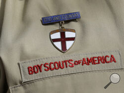 FILE - A close up of a Boy Scout uniform is photographed on Feb. 4, 2013, in Irving, Texas. On Tuesday, March 28, 2023, a federal district court judge upheld the approval of a $2.4 billion bankruptcy reorganization plan aimed at resolving tens of thousands of child sexual abuse claim against the Boy Scouts of America. (AP Photo/Tony Gutierrez, File)