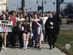 More than 100 people, many of them transgender youth, march around the Kansas Statehouse on the annual Transgender Day of Visibility, Friday, March 31, 2023, in Topeka, Kan. While the event was a celebration of transgender identity, it also was a protest against proposals before the Kansas Legislature to roll back transgender rights. (AP Photo/John Hanna)