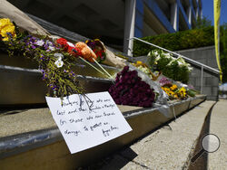 Flowers and a message of hope sit on the steps of the Old National Bank in Louisville, Ky., Tuesday, April 11, 2023. On Monday, a shooting at the bank located in downtown Louisville killed several people and wounded others. (AP Photo/Timothy D. Easley)