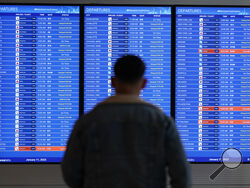 FILE - A traveler looks at a flight board with delays and cancellations at Ronald Reagan Washington National Airport in Arlington, Va., Wednesday, Jan. 11, 2023. Congressional investigators said in a report Friday, April 28, 2023, that an increase in flight cancellations as travel recovered from the pandemic was due mostly to factors that airlines controlled, including cancellations for maintenance issues or lack of a crew. (AP Photo/Patrick Semansky, File)