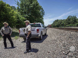 Authorities search near train tracks, in Cleveland, Texas, Monday, May 1, 2023, for a suspect who fatally shot five neighbors several days earlier. (Raquel Natalicchio/Houston Chronicle via AP)