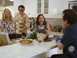 This image released by Apple TV+ shows, from left, Tracy Pollan, Sam Fox, Esme Fox and Michael J. Fox in a scene from the documentary "Still: A Michael J. Fox Movie." (Apple TV+ via AP)