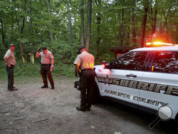 Authorities secure the entrance to Mine Bank Trail, an access point to the rescue operation along the Blue Ridge Parkway where a Cessna Citation crashed over mountainous terrain near Montebello, Va., Sunday, June 4, 2023. (Randall K. Wolf via AP)