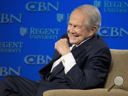 FILE - Rev. Pat Robertson listens as Republican presidential candidate Donald Trump speaks at Regent University in Virginia Beach, Va., Feb. 24, 2016. Robertson, a religious broadcaster who turned a tiny Virginia station into the global Christian Broadcasting Network, tried a run for president and helped make religion central to Republican Party politics in America through his Christian Coalition, has died. He was 93. Robertson's death Thursday, June 8, 2023 was announced by his broadcasting network. (AP Ph