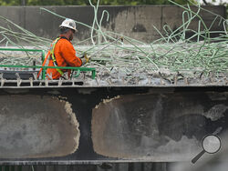 A construction worker cuts rebar at the scene of a collapsed elevated section of Interstate 95, Wednesday, June 14, 2023, in Philadelphia. (AP Photo/Matt Rourke)