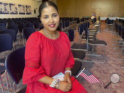 Heaven Mehreta, 32, smiles and holds a small American flag inside Mount Zion Temple in St. Paul, Minn., June 21, 2023, after becoming a U.S. citizen at a naturalization ceremony that day in the synagogue. Mehreta immigrated from Ethiopia 10 years ago, learned English as an adult and passed the U.S. citizenship test in May. The test is being updated and some immigrants, including Mehreta, worry the changes will hurt test-takers with lower levels of English proficiency. (AP Photo/Trisha Ahmed)