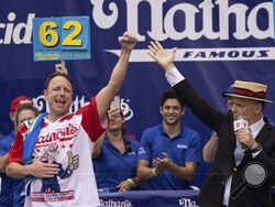 Joey Chestnut celebrates after winning his 16th championship title during the 2023 Nathan's Famous Fourth of July hot dog eating contest in the Coney Island section of the Brooklyn borough of New York, Tuesday, July. 4, 2023. (AP Photo/Yuki Iwamura)