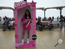 An anti-government protester, dressed as Barbie holding a fake gun, takes part in a demonstration demanding that Peruvian President Dina Boluarte call for immediate presidential elections as well as justice for those who were killed during protests earlier this year after the ouster of her predecessor, in Lima, Peru, Saturday, July 22, 2023. (AP Photo/Martin Mejia)