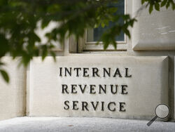 FILE - A sign outside the Internal Revenue Service building in Washington, on May 4, 2021. Effective immediately, the Internal Revenue Service will end its decades-old policy of making unannounced home and business visits — in a nod to worker safety and combatting scammers who pose as IRS agents. (AP Photo/Patrick Semansky, File)