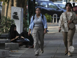 Iranian women walk in Tehran, Iran, Saturday, Aug. 5, 2023. These days, with uncovered women a common sight on Tehran streets, authorities have begun raiding companies where women employees or customers have been seen without the headscarf, or hijab. Iran's parliament is discussing a law that would increase punishments on uncovered women and the businesses they frequent. (AP Photo/Vahid Salemi)