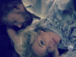 This early Wednesday, Aug. 9, 2023, photo provided by Cindy Curler shows Cindy and her husband Bob Curler laying on a couch in the garage office of the limousine after their wedding in Lahaina on Maui, Hawaii. The Pittsburgh couple were unable to get back to their Lahaina hotel Tuesday on their wedding night as wildfires swallowed the town. Their driver was forced to take them to the garage where he parks his limousine. (Courtesy of Cindy Curler via AP)