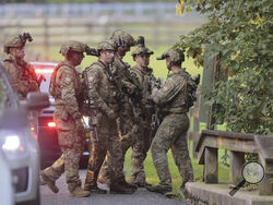 Pennsylvania State police search the woods and a creek in Pennsbury Township, Pa., on Tuesday, Sept. 5, 2023. Murderer Danelo Cavalcante was able to escape a prison yard in suburban Pennsylvania last week by climbing up a wall and over razor wire, officials said at a news conference Wednesday. (Steven M. Falk/The Philadelphia Inquirer via AP)