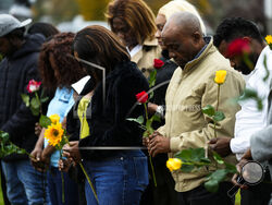 Members of the New Apostolic Church sing a pray at a makeshift memorial outside a bowling alley, the site of one of this week's mass shootings, Sunday, Oct. 29, 2023, in Lewiston, Maine. A gunman killed multiple people at the bowling alley and a bar in Lewiston on Wednesday. (AP Photo/Matt Rourke)