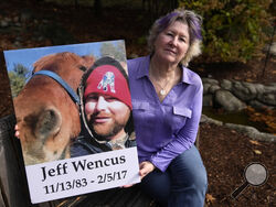 Lynn Wencus, of Wrentham, Mass., holds a photograph of her son Jeff while seated in a garden at her home, in Wrentham, Tuesday, Nov. 7, 2023. Wencus lost Jeff to a heroin overdose in 2017. Families who lost loved ones to overdose are divided over OxyContin maker Purdue Pharma's plan to settle lawsuits over the toll of opioids with governments. It could provide billions to address an overdose epidemic and pay some victims. But it would also protect members of the Sackler family who own the company from futur