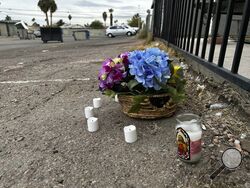 A makeshift memorial for a high school student lines a fence along an alleyway near Rancho High School in eastern Las Vegas on Wednesday, Nov. 15, 2023. Authorities arrested eight teens Tuesday in connection with the beating of Jonathan Lewis Jr., who died a week after a prearranged fight over a pair of headphones and a vape pen. (AP Photo/Rio Yamat)