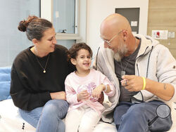 This photo released by Schneider Children's Medical Center on Monday, Nov. 27, 2023 shows Abigail Edan, center, who returned last night to Israel, with her aunt Liron, left, and her uncle Zuli, right. Abigail was one of the third group of hostages released by Hamas on Sunday. Abigail's parents were both killed by Hamas militants in the same attack in which she was kidnapped, a cross-border assault Oct. 7 that prompted Israel to declare war on Hamas. (Spokesperson's Office, Schneider Children's Medical Cente