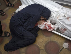 A woman mourns her child and her husband killed in an Israeli army bombardment of the Gaza Strip, in the hospital in Khan Younis, Tuesday Dec. 5, 2023. (AP Photo/Fatima Shbair)