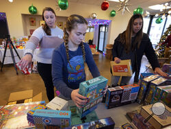 Molly Armbrecht, center, arranges toys at The Toy Store, a free-referral based toy store Thursday, Dec. 7, 2023, in Nashville, Tenn. The facility is co-founded by Brad Paisley and Kimberly Williams-Paisley. The couple also started The Store, a free-referral based grocery store they opened in partnership with Belmont University in March 2020. (AP Photo/Mark Humphrey)