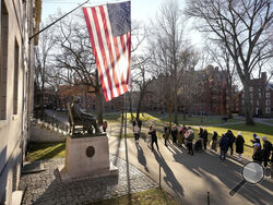 FILE - People take photos near a John Harvard statue, left, on the Harvard University campus, Tuesday, Jan. 2, 2024, in Cambridge, Mass. On Wednesday, Jan. 10, several Jewish students filed a lawsuit against Harvard University, accusing it of becoming “a bastion of rampant anti-Jewish hatred and harassment.” (AP Photo/Steven Senne, File)