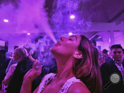 AP FILE PHOTO - A guest takes a puff from a marijuana cigarette at the Sensi Magazine party celebrating the 420 holiday in the Bel Air section of Los Angeles, April 20, 2019.