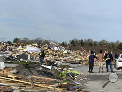 People pick through the rubble of a house that was leveled in Elkhorn, Neb., on Saturday. (AP Photo/Nick Ingram)