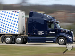 A self-driving tractor trailer maneuvers around a test track in Pittsburgh, Thursday, March 14, 2024. The truck is owned by Pittsburgh-based Aurora Innovation Inc. Late this year, Aurora plans to start hauling freight on Interstate 45 between the Dallas and Houston areas with 20 driverless trucks. (AP Photo/Gene J. Puskar)