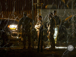 AP Photo/Andres Leighton Texas Army National Guard members talk while patrolling behind razor wire on the banks of the Rio Grande in El Paso, Texas, seen from Ciudad Juarez, Mexico, late Thursday, Aug. 8.