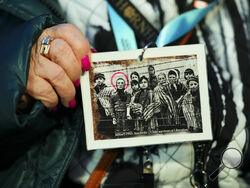 Sean Kilpatrick/The Canadian Press via AP Canadian Holocaust survivor Miriam Ziegler holds up a photo of her (circled) as as she attends the Commemoration Ceremony of the 80th Anniversary of the Liberation of Auschwitz, in Oswiecim, Poland, on Monday.
