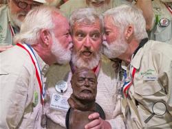 In this Saturday, July 23, 2016 photo provided by the Florida Keys News Bureau, Dave Hemingway, center, receives smooches from Charlie Boise, left, and Wally Collins, right, after Hemingway won the 2016 Ernest "Papa" Hemingway Look-Alike Contest in Key West, Fla. (Rob O'Neal/Florida Keys News Bureau via AP)