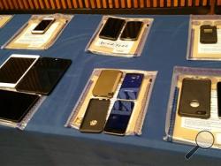 A collection of Apple iPhones and iPads fill a table during a news conference at New York City Police Headquarters, Thursday, Feb. 18, 2016 in New York. Police and prosecutors in New York City said Thursday that the top-notch encryption technology on Apple mobile phones is now routinely hindering criminal investigations. And they predicted the problem could grow worse as more criminals figure out how well the devices keep secrets. (AP Photo/Verena Dobnik)