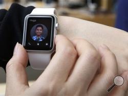 In this April 10, 2015, file photo, a customer tries on an Apple Watch at an Apple Store in Hong Kong. (AP Photo/Kin Cheung, File)