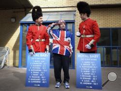 Royal supporter John Loughrey, center, salutes as he stands with men dressed as soldiers carrying boards with proposed baby names on, outside the Lindo Wing of St Mary's Hospital in London, Friday, May 1, 2015. Kate, The Duchess of Cambridge is due to give birth at the hospital in the next few days. (AP Photo/Kirsty Wigglesworth)