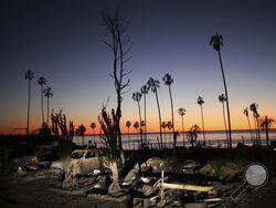 The devastation of the Palisades Fire is seen at sunset in the Pacific Palisades neighborhood of Los Angeles, Tuesday, Jan. 14, 2025. (AP Photo/Ethan Swope)