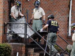 Investigators from the Bureau of Alcohol, Tobacco, Firearms and Explosives and the South Carolina Law Enforcement Division remove the remains of a door from the Mount Zion African Methodist Episcopal Church, Wednesday, July 1, 2015, in Greeleyville, S.C. The African-American church, which was burned down by the Ku Klux Klan in 1995, caught fire Tuesday night, but authorities said arson is not the cause. (Veasey Conway/The Morning News via AP)