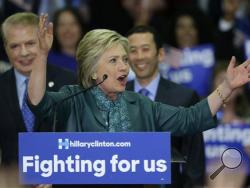 Democratic presidential candidate Hillary Clinton, center, speaks as Seattle Mayor Ed Murray, left, and his husband, Michael Shiosaki, right, look on Tuesday, March 22, 2016, during a campaign rally at Rainier Beach High School in Seattle. (AP Photo/Ted S. Warren)