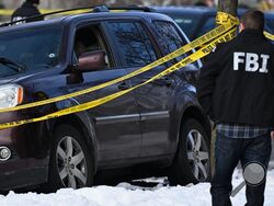 A bullet hole is seen in the windshield as law enforcement officers work the scene of a shooting involving federal law enforcement agents, Wednesday, Jan. 7, 2026, in Minneapolis. (AP Photo/Tom Baker)