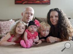 In this Sept. 1, 2014, photo, Willow Short, 4-month-old, center, along with her parents Megan and Mark and sister Liana, 6, and brother Mark, 3, poses for a photo in Sinking Spring, Pa. Willow Short had a heart transplant at 6-days-old. (Susan L. Ang