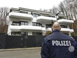 A police officer stands in front of an apartment building where they believe Andreas Lubitz, the co-pilot of the crashed Germanwings airliner jet, lived in Duesseldorf, Germany, Thursday, March 26, 2015, during an investigation into the crash in the French Alps on Tuesday that killed 150 people. (AP Photo/Martin Meissner)