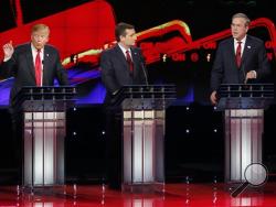 Donald Trump, left, and Jeb Bush, right, both speak as Ted Cruz looks on during the CNN Republican presidential debate at the Venetian Hotel & Casino on Tuesday, Dec. 15, 2015, in Las Vegas. (AP Photo/John Locher)